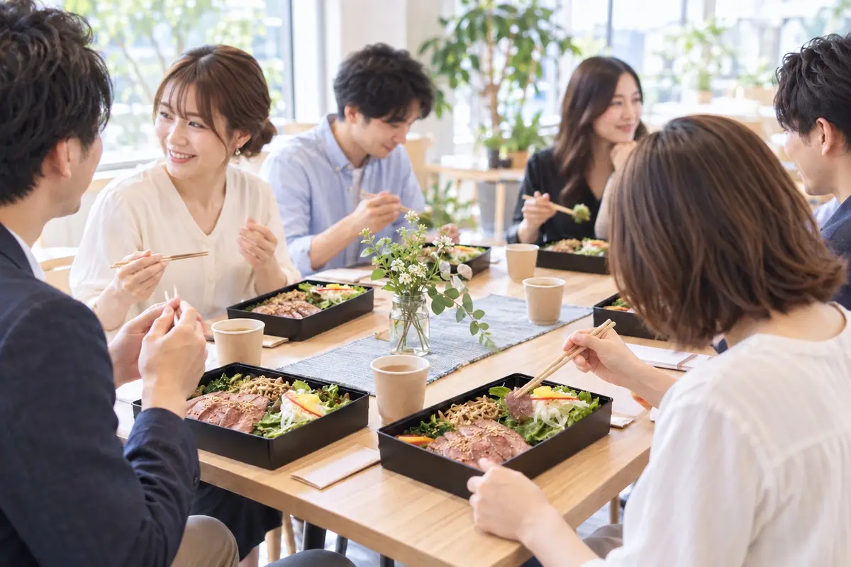 明るい会場でお弁当を囲み、自然に会話を楽しむ男女